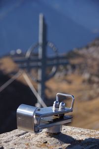 Close-up of sunglasses on land against blue sky