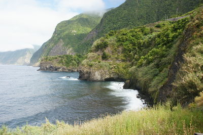 Scenic view of sea and mountains against sky