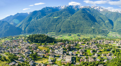 Aerial view of townscape and mountains against sky