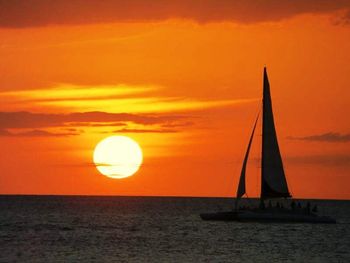 Boat sailing in sea at sunset