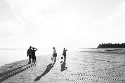 People at beach against sky