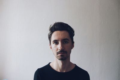 Portrait of serious young man against white background