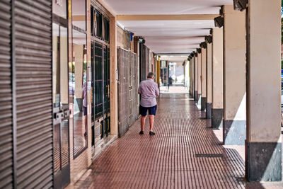 Rear view of woman walking in corridor of building