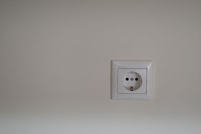 Close-up of electric lamp against white wall