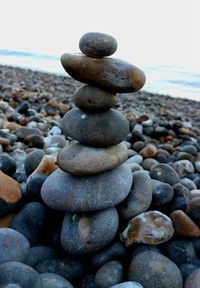 Stack of pebbles on beach against sky