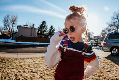 Portrait of goofy girl making silly face in front yard