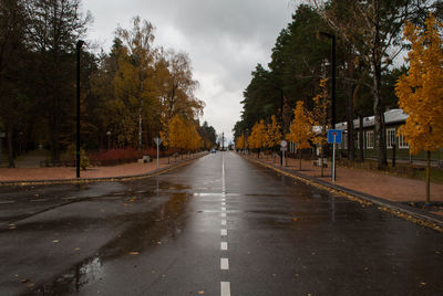 Road amidst trees against sky during autumn