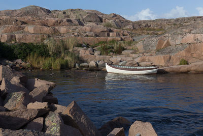 Boat at lake against rocks