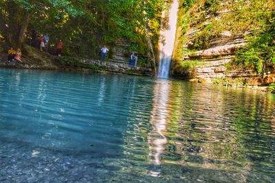 People by swimming pool in river