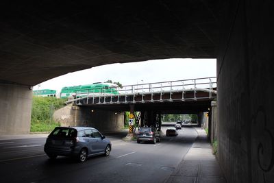 Cars on road by bridge