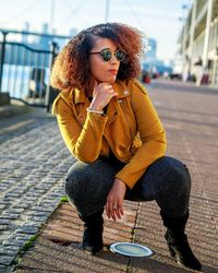 Young woman using mobile phone while standing in city