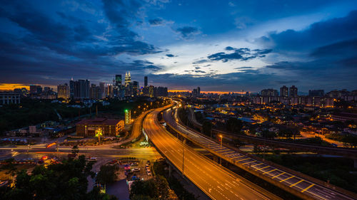 High angle view of light trails on road amidst buildings in city