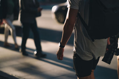 Low section of people walking on street in city