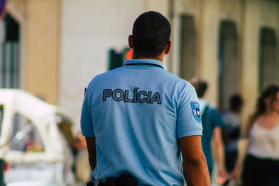 Rear view of man standing on street in city