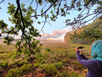 Man photographing against sky