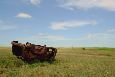 Abandoned truck on field against sky