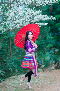 Woman with pink umbrella standing in rain