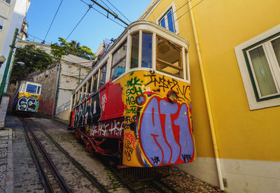 Train on railroad track in city against sky