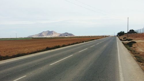 Road by landscape against sky