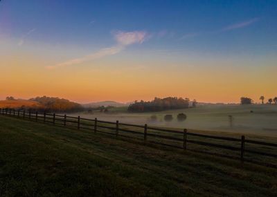 Scenic view of agricultural field against sky during sunset