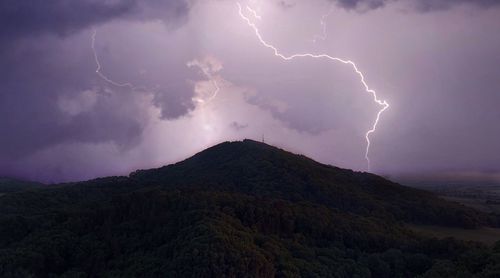 Lightning over mountains against dramatic sky