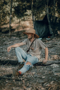 Full length of young man sitting on land