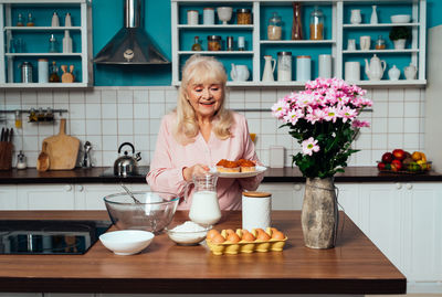 Smiling senior woman making cupcakes