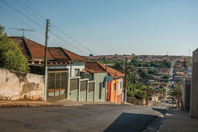 Downhill street view with sidewalk walls and colorful houses on a sunny day at são manuel, brazil.