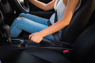 Midsection of woman sitting in car