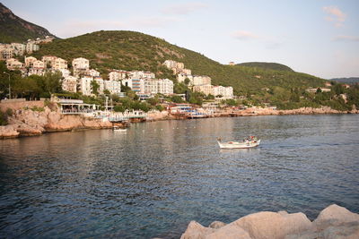 Scenic view of sea by townscape against sky