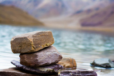 Stack of rocks by sea against sky