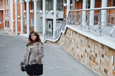 Young female model posing on road in city