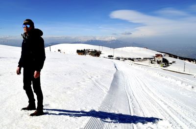 Full length of man standing on snow covered land during winter