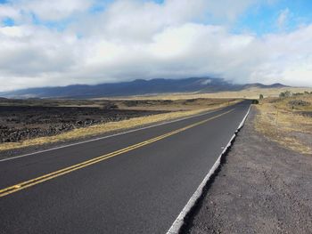 Empty road against cloudy sky