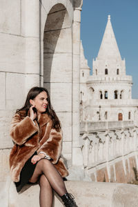 Stylish young woman standing on balcony at fisherman's bastion in budapest, hunagry