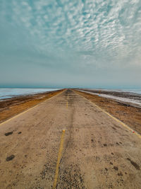 Scenic view of road against sky in the middle of a white desert.