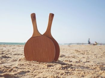 Close-up of table tennis rackets at beach against sky