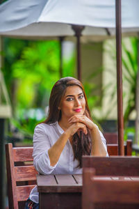 Portrait of young woman sitting on table