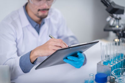 Midsection of man working in pen