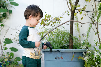 Boy playing with a stick in the garden