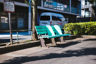 Empty bench in park at roadside