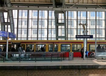 People at railroad station against sky