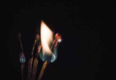 Close-up of illuminated candle against black background