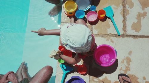 Low section of woman standing by swimming pool