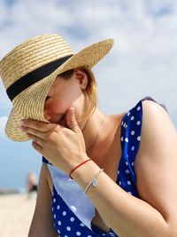 Smiling woman wearing hat against sky