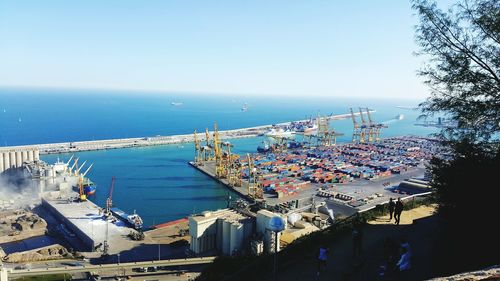 High angle view of ship moored at harbor against clear sky