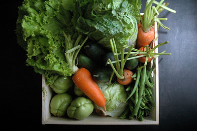 High angle view of vegetables in container against black background