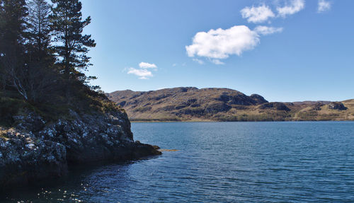 Scenic view of sea and mountains against sky