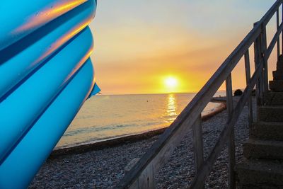 Close-up of beach against sky during sunset