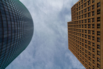 Low angle view of modern building against cloudy sky